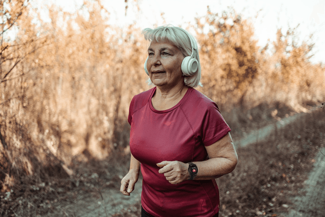 Indy Smartwatch worn on a senior man's wrist while he reads in a comfortable armchair, close-up showing the modern watch face - view 4